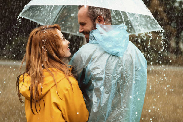 istock Delighted couple hiding under umbrella 1143045811