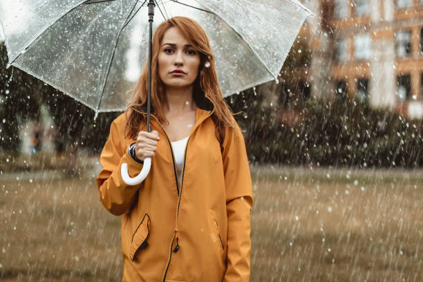 istock Dissatisfied woman standing outside in rain 1143045858