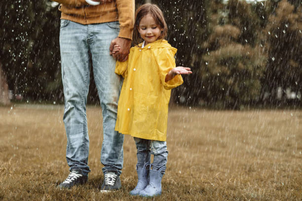 istock Father and daughter playing in rain 1143045863