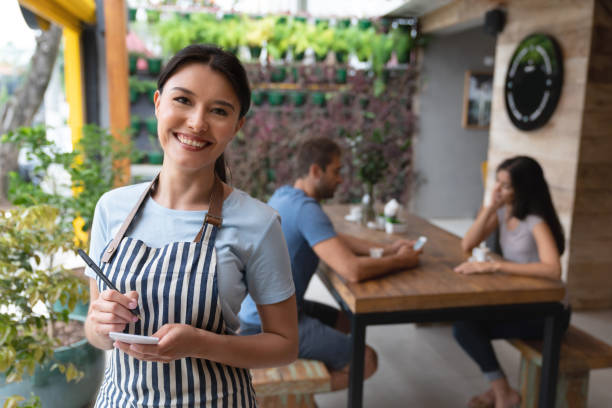 istock Friendly waitress working at a cafe and smiling 1143046098