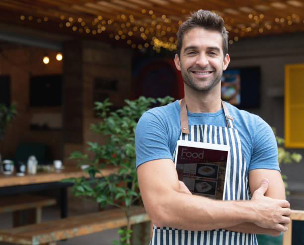 istock Happy business owner working at a restaurant holding a tablet computer 1143046137