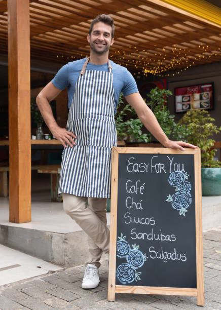 istock Happy business owner posing next to the menu board at a cafe 1143046140