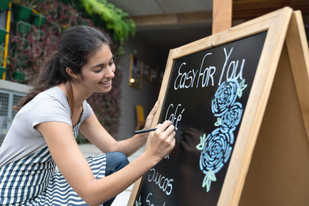 istock Waitress working at a cafe writing the menu on a blackboard 1143046152