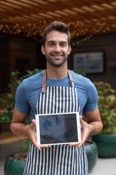 istock Happy business manager working at a restaurant holding a tablet computer 1143046159