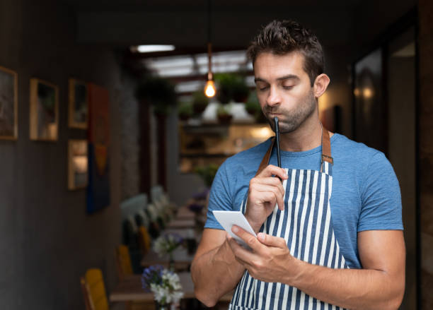 Thoughtful waiter looking at his notepad at a restaurant
