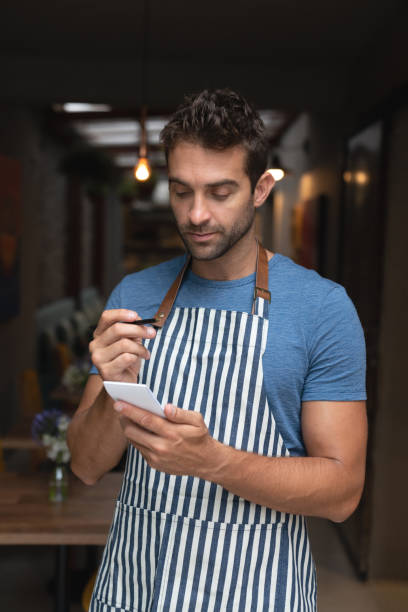 istock Waiter working at a cafe and writing on a notepad 1143046177