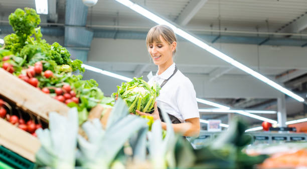 istock Woman working in a supermarket sorting fruit and vegetables 1143046531