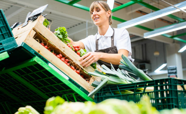 Woman working in a supermarket sorting fruit and vegetables Woman working in a supermarket sorting fresh fruit and vegetables nylon stock pictures, royalty-free photos & images