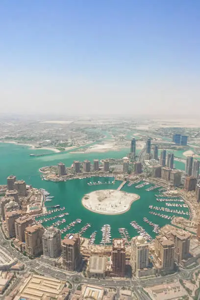 Qatar view from a plane's window with airplane wing. Doha city corniche bay marina view taken from passenger view