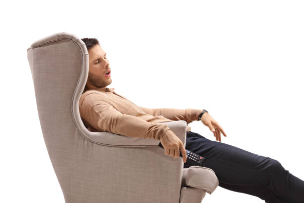 istock Young guy with a remote control sleeping in an armchair 1143050297