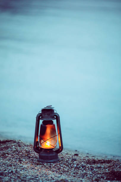 istock Oil lamp on the beach at sunset. Vertical frame 1143050374