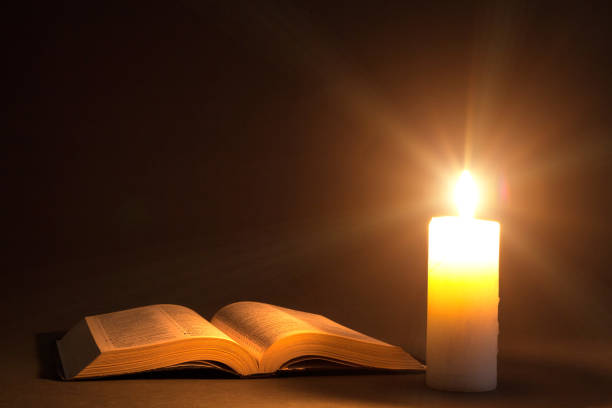 istock a bible on the table in the light of a candle 1143052090