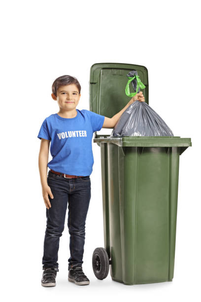 istock Boy volunteer throwing a waste bag into a bin 1143052495
