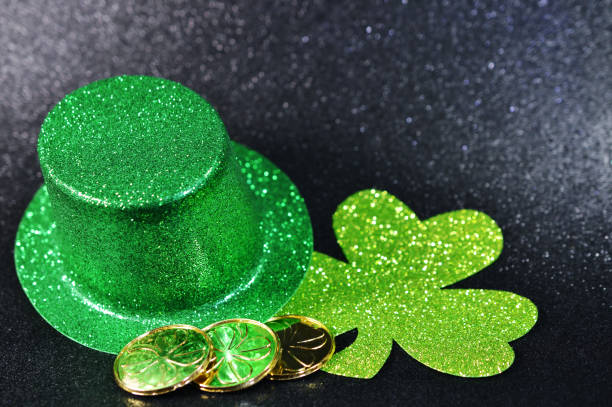 istock Saint Patrick's Day Top Hat with Shamrock and coins on black background 1143052965