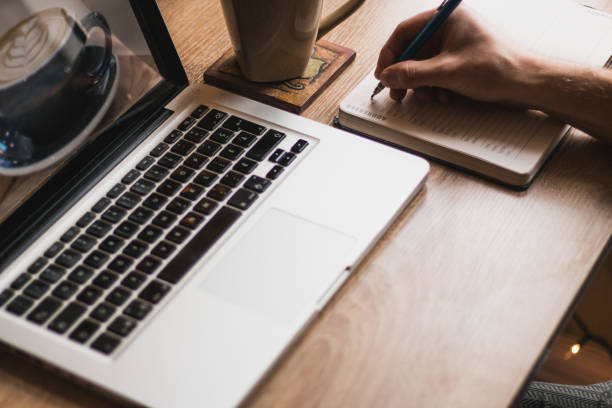 istock A workplace with a man typing on a laptop or writing on a notepad. 1143054078