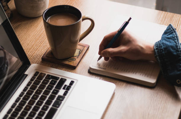 istock A workplace with a man typing on a laptop or writing on a notepad. 1143054098