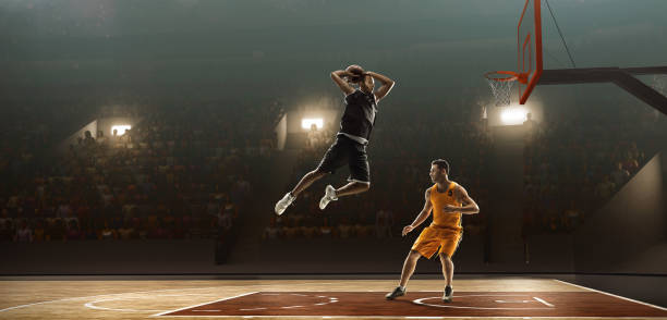 Two professional basketball players fight fo a ball Two professional basketball players on a professional sports arena fight fo a ball. One of the players scores bouncing photos stock pictures, royalty-free photos & images