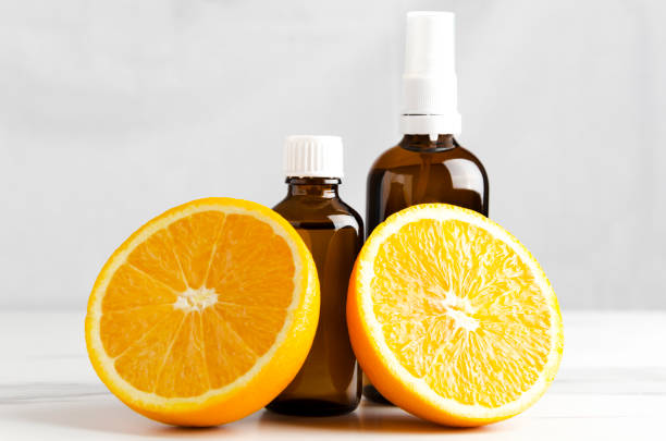 istock Juicy oranges and bottles with aromatic oils for aroma therapy standing on white table against wall 1143057576