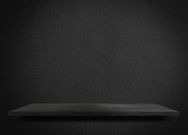 istock Empty black wooden shelf on black cement wall 1143057953