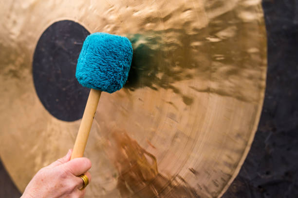 gong meditation, Hand holds a mallet and beats a gong stock photo
