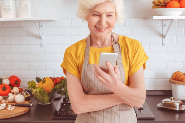 istock Grandmother looks on the internet and laughs 1143057998