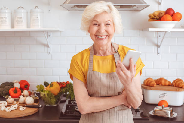 istock Handsome old woman holding new mobile device and smiling 1143058003