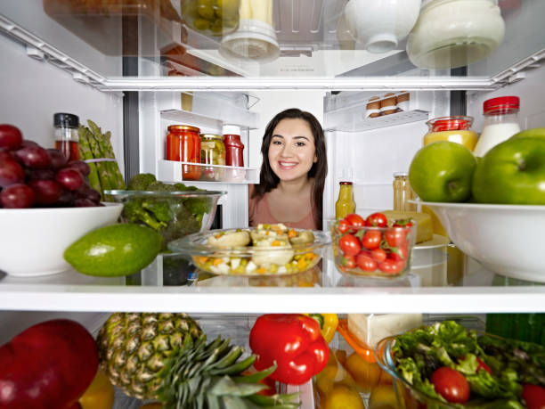 istock Young woman looking inside the fridge 1143059582