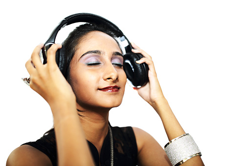 Beautiful girl in casual wear using headphone to listen music.