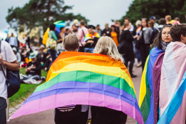 zwei mädchen mit regenbogenfahne im garten kaivopuisto - lesbian gay man rainbow multi colored stock-fotos und bilder