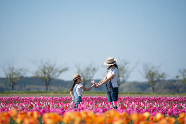 istock Mother and daughter handing a tulip 1143063700