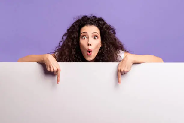 Photo of Close-up portrait of her she nice cute attractive charming amazed brunette wavy-haired lady pointing two forefingers down large ad advert isolated over bright vivid shine violet purple background