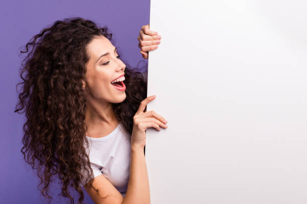 close-up portrait of nice cute attractive charming cheerful cheery brunette wavy-haired lady showing looking aside large ad advert isolated over bright vivid shine violet purple background - aside imagens e fotografias de stock