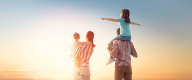 istock happy family at sunset. 1143065145