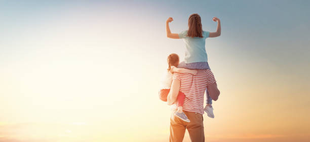 istock happy family at sunset. 1143065146