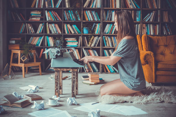 istock Young woman writer in library at home creative occupation typing concentrated 1143066405