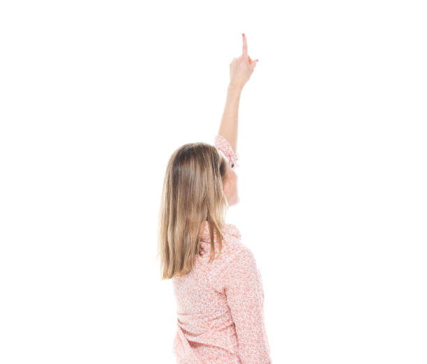 istock Good looking white female standing on white background - pointing up 1143068191