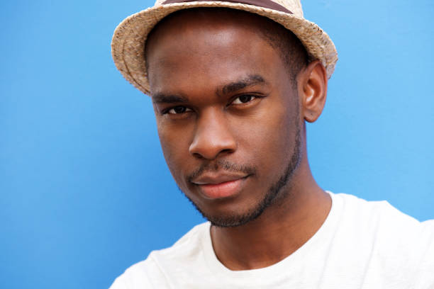 istock Close up cool young black guy with hat against blue background 1143072612
