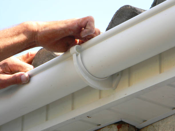 istock Contractor installing plastic roof gutter. Plastic Roof Guttering Renovation, Rain Guttering Repair & Drainage by Handyman hands. 1143073716