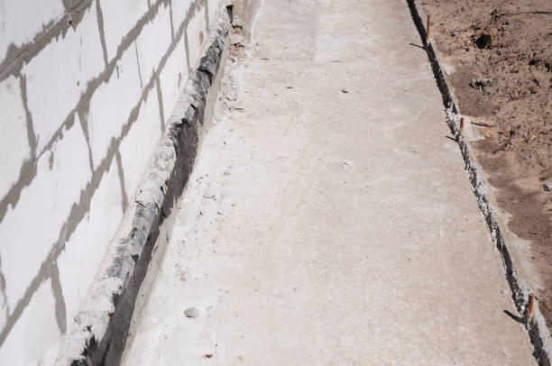 istock Close up on house foundation waterproofing, damp proofing with contrete path to avoid water leaks for home wall. 1143074177