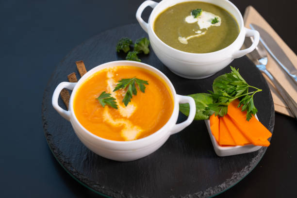 two bowls of pumpkin and broccoli soup with cream - portion pumpkin vegetable black imagens e fotografias de stock