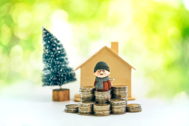 istock Retirement planning Concept of miniature old man figure standing on coin stack 1143078666