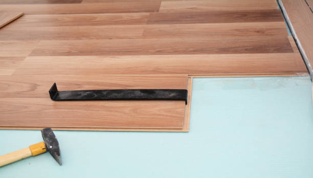 istock Install  wooden laminate flooring with insulation, tools and soundproofing sheets. 1143080236