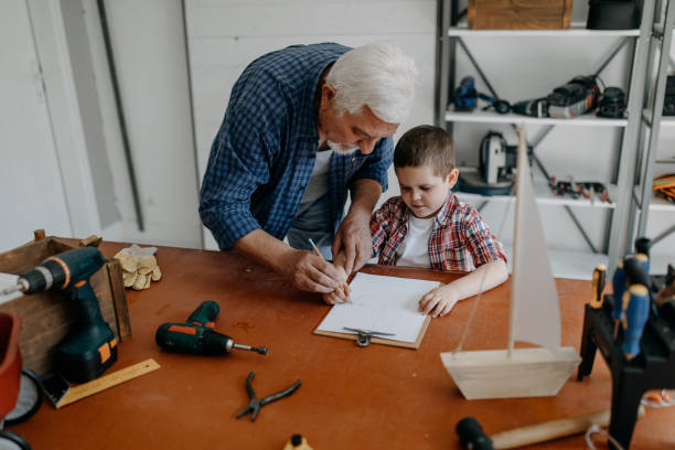 istock Grandfather and grandson building a ship 1143080969