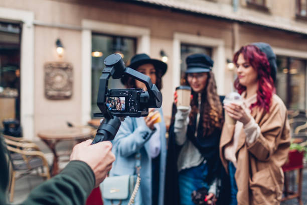 istock Videographer filming models on city street. Man using steadicam and camera to make footage. Video shoot 1143081249