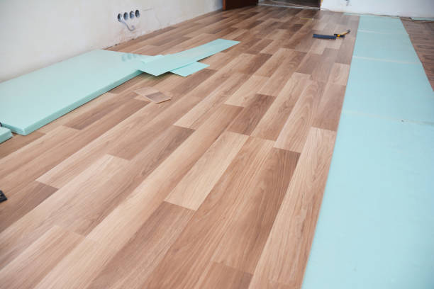 istock Installing wooden laminate flooring with insulation and soundproofing sheets. 1143081991