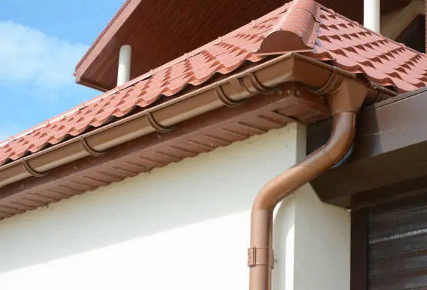 House attic metal roof with soffits, fascias,  roof  guttering, downspout gutter pipe.