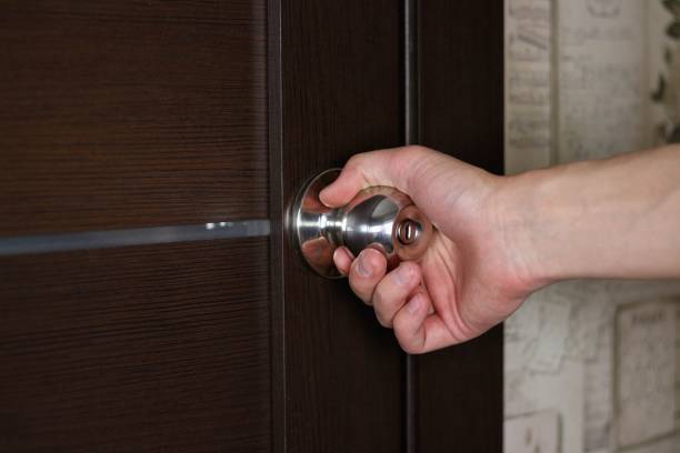istock Hand opens the door by the handle. Close up 1143083243