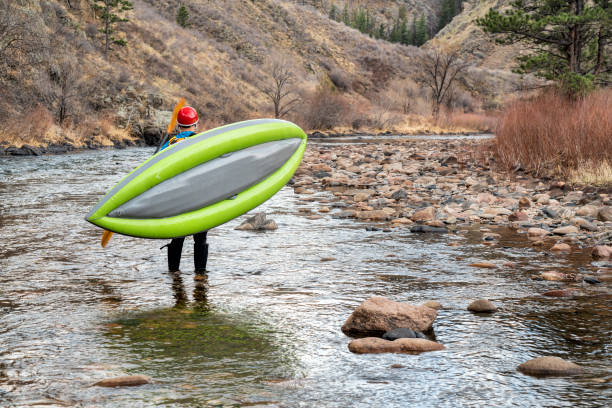 istock paddler carrying  inflatable whitewater kayak 1143083351