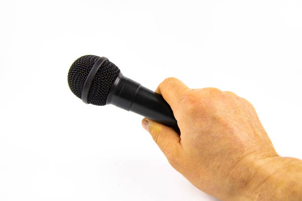 istock Black microphone in a man's hand on a white background. 1143084649