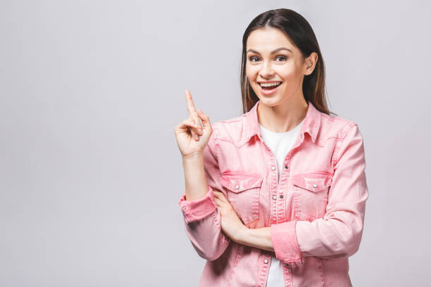 istock Image of happy young lady standing isolated over white background. Looking camera pointing. 1143087546